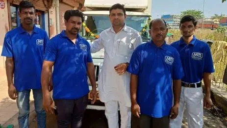 Metro packers and Movers in Mansarovar Team in blue tshirts standing front of  moving truck
